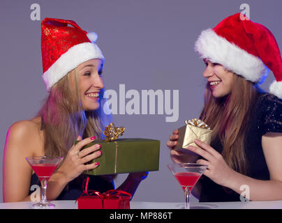 Freundinnen in Weihnachten Hüte mit Cocktails feiern das neue Jahr Stockfoto