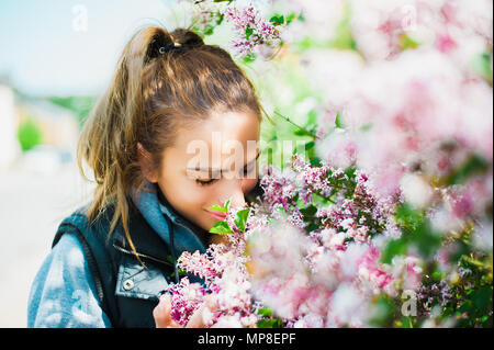 Schöne, junge Frau duftende Blumen Stockfoto