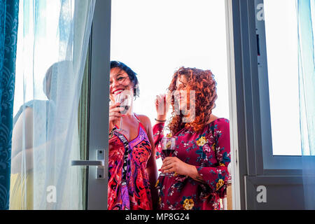 Drei kaukasischen Frauen Junge zu Hause im Freien auf der Terrasse, Feier und Party time Trinken einer Tasse Wein. Lächeln und Glück in der Freundschaft Stockfoto