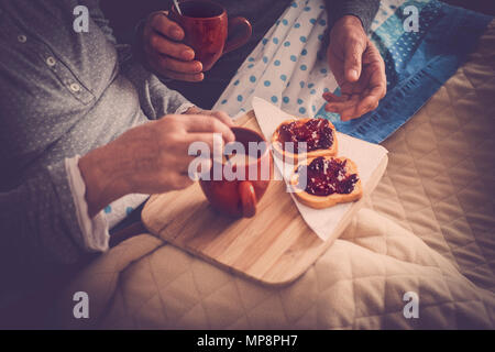 Paar der älteren Menschen verheiratet Ruhe im Bett und das Frühstück und eine Tasse Tee oder Kaffee genießen. Glücklich im Ruhestand kaukasischen Mann und Frau Stockfoto