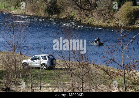 Der Lachsfang in den Fluss Tweed in Kelso, mit 4X4 auf dem hölzernen Anna Insel und in Tarnanzügen durch Boot auf dem Wasser geparkt. Stockfoto