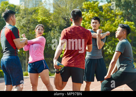 Jungen asiatischen Erwachsene Aufwärmen stretching Ars und Beinen am Anschluss Stockfoto