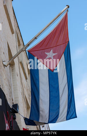 Die kubanische Flagge Kuba auf einem Fahnenmast mit blauen Himmel. Stockfoto