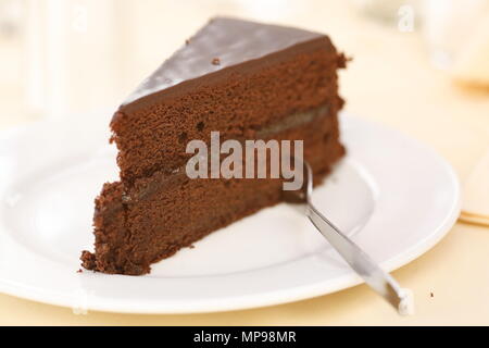 Stück Schokolade Kuchen im Stil von Sacher auf einem Teller mit der Gabel Stockfoto
