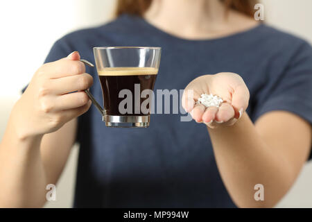 Vorderansicht Nahaufnahme einer Frau Hände halten eine Tasse Kaffee und saccharin Pillen Stockfoto