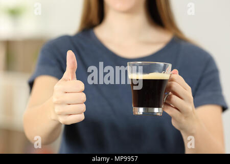 Vorderansicht Nahaufnahme einer Frau Hände halten eine Tasse Kaffee mit Daumen hoch zu Hause Stockfoto