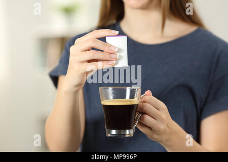 Vorderansicht Nahaufnahme eines Frau Hände Saccharin werfen in eine Tasse Kaffee zu Hause Stockfoto