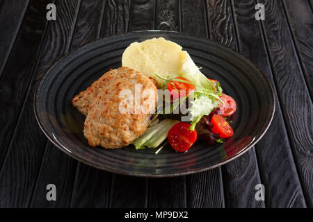 Schnitzel mit Kartoffelpüree, Salat und Tomaten Stockfoto