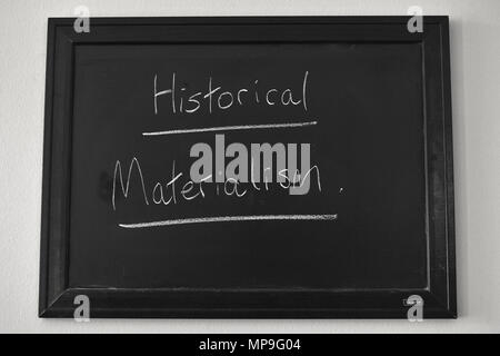 Der historische Materialismus in weißer Kreide auf einer Tafel an der Wand montiert. Stockfoto