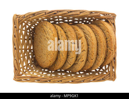 Ein kleiner Weidenkorb mit mehreren brauner Zucker und Zimt cookies auf einem weißen Hintergrund. Stockfoto