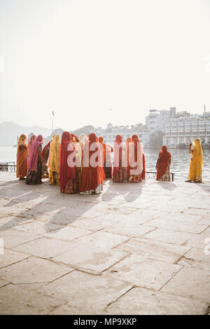 Schön und farbenfroh gekleidete indische Frauen ein Tod, Trauern und ihre Kleidung in den See in Udaipur, Indien waschen Stockfoto