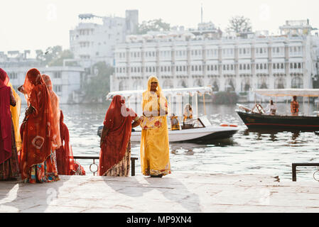 Schön und farbenfroh gekleidete indische Frauen ein Tod, Trauern und ihre Kleidung in den See in Udaipur, Indien waschen Stockfoto