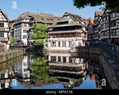 Touristen, die die Banken als traditionelle Gebäude sind in der Ill, in der Altstadt von Straßburg, Frankreich Stockfoto