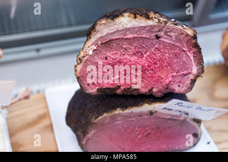 Raw rosa Roastbeef Stücken in Markt mit Reflexion im Regal, teuren Preis pro Pfund Stockfoto