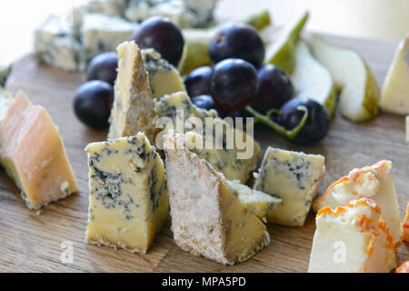 eingestellt von Käse mit Schimmel auf einem Holzbrett mit Trauben und Birnen Stockfoto