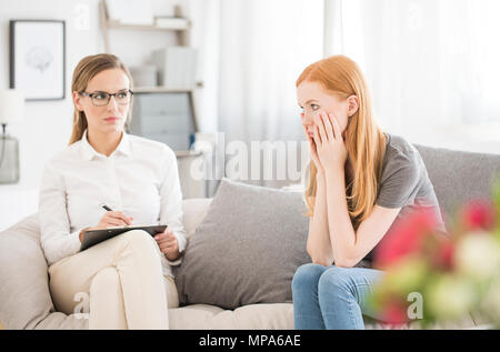 Traurig weiblichen Patienten mit psychischen Problemen auf psychologische Therapie Sitzung Stockfoto