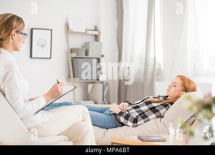 Psychische Gesundheit Konzept - Patient liegt auf der Couch in der Psychologe, Psychologin Notizen Stockfoto