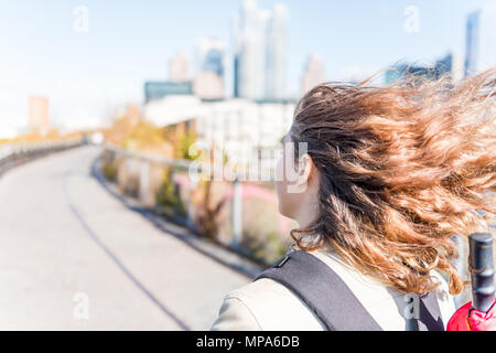 NYC im Highline, High Line, urban mit Menschen Touristen Frau zu Fuß mit Rucksack, Regenschirm Chelsea West Side von Hudson Yards im Herbst gelb g Stockfoto