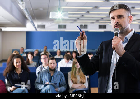 Akademischer Lehrer im Gespräch mit seinen Studenten im Hörsaal Stockfoto