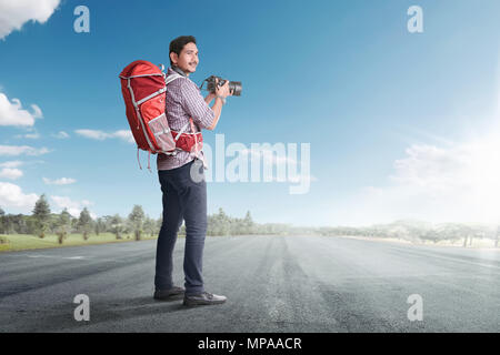 Junge asiatische Touristen mit Rucksack und Kamera auf der leeren Straße Stockfoto