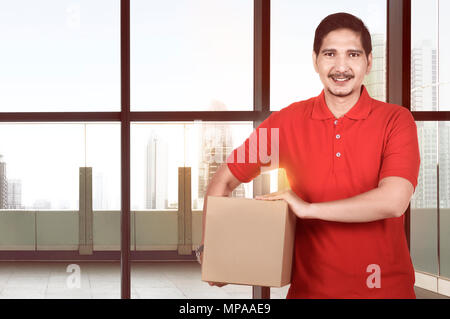 Attraktiven asiatischen Lieferung Mann, der auf dem Office Paket Stockfoto