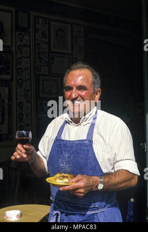 1988 historische BARPERSON TOASTS MIT GLAS ROTWEIN CAFE AU SAUVIGNON RUE DES SAINTS PERES, Paris, Frankreich Stockfoto