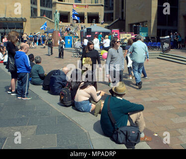 Einheimische und Touristen sitzen den sonnenschein sonnig Wetter auf den Konzertsaal Schritte genießen, an der Spitze der Buchanan Street Unten der Sauchiehall Street Stockfoto