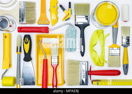 Pinsel, Rollen, Dosen, Handschuhe, Schutzbrille, Spachtel, Lack Fach auf weißem Hintergrund Holz flache Ansicht Stockfoto