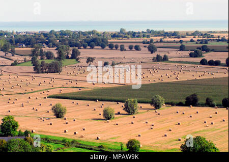 Ein schöner Panoramablick auf eine ländliche Bauerngemeinde mit Feldern voller Heuballen in der Bretagne, Frankreich. Stockfoto