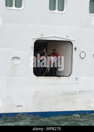 Coast Guard Personal und Crewmitglieder mit der Royal Caribbean International Kreuzfahrten Grandeur of the Seas bereiten einem Angeschlagenen Passagier in einem 45-Fuß Antwort Boat-Medium Crew von Station Little Creek östlich der Chesapeake Bay Bridge Tunnel, 7. April 2017. Die Küstenwache hatte einen Anruf von kreuzfahrtschiff Personal davon, dass eine 60-jährige männliche Beifahrer litt Atemstillstand und musste Not Transport zum Ufer empfangen. Stockfoto