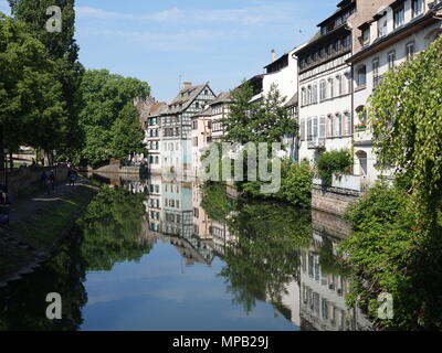 Friedliche und ruhige Fluss mit Reflexion als Menschen im Schatten des grünen Bäumen, Straßburg, Frankreich Stockfoto