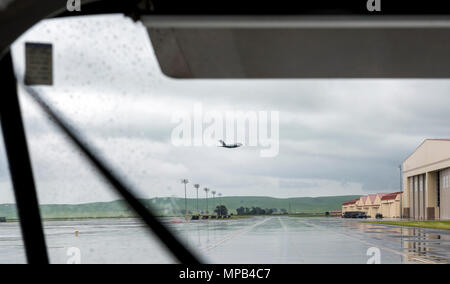 Eine c-17 Globemaster gesehen durch eine Besatzung Bus Windschutzscheibe lässt an einem regnerischen Morgen, 7. April 2017 Travis Air Force Base. Die Boeing c-17 Globemaster III ist eine große militärische Transportflugzeuge. Es wurde von McDonnell Douglas für die United States Air Force (USAF) aus den 1980er Jahren zu den frühen 1990er Jahren entwickelt. Die c-17 trägt den Namen der zwei vorherigen Kolbenmotor militärische Frachtflugzeuge, die Douglas C-74 Globemaster und Douglas C-124 Globemaster II. Die c-17 führt häufig strategische Luftbrücke Missionen, den Transport von Truppen und Fracht in der ganzen Welt; zusätzliche Rollen gehören taktische Ki Stockfoto