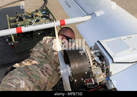 Sgt. Eric Blanton, ein unbemanntes Flugzeug Systeme für Unternehmen D, Feuerwehr 588th Engineer Battalion, 3. gepanzerte Brigade Combat Team, 4 Infanterie Division repairer, perofrms Wartung auf einen RQ-7B Shadow Unmanned Aerial Systems nach einem Flug für weitere Operationen als Teil der atlantischen Ausbildung lösen an der Rose Barracks, Vilseck, Deutschland, 9. April 2017 zu tanken. Die Brigade UAS platoon ist die Integration in die Manöver und Field Artillery Einheiten route Aufklärung, Zielerfassung und Über-watch für Bodentruppen auf dem Schlachtfeld. Stockfoto