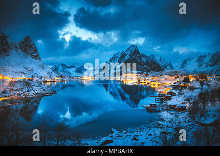 Klassische Ansicht der berühmten Fischerdorf Reine mit Olstinden Peak im Hintergrund in magischen Winter Abend dämmerung, Lofoten, Norwegen Stockfoto