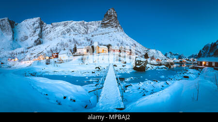 Berühmten Fischerdorf Reine mit einer kleinen Brücke in magischen Morgendämmerung in der Dämmerung im Winter Dorf Reine, Lofoten, Norwegen Stockfoto