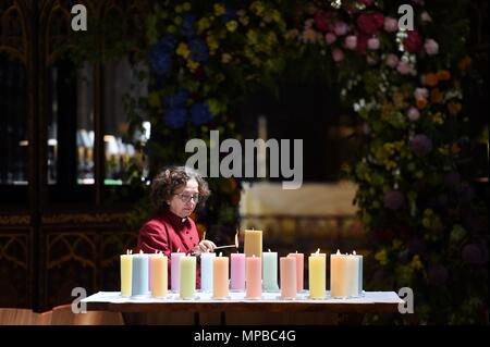 Ein Mitglied des Klerus leuchten Kerzen für die Opfer während der Manchester Arena National Service der Gedenkfeier in der Kathedrale von Manchester zu einem Jahr seit dem Angriff auf Manchester Arena. Stockfoto