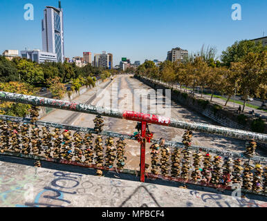 Gewölbte Fußgängerbrücke über niedrigen Fluss Mapocho mit Masse der Liebe Schlösser, Racamalac Brücke, Santiago, Chile Stockfoto