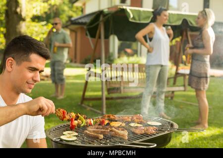 Schuss von einer Gruppe von Freunden grillen im Garten Stockfoto