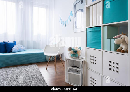 Gemütliche moderne Zimmer für kleine Junge entwickelt. Grauer Teppich auf Holzboden Stockfoto