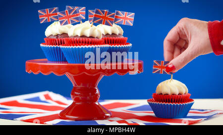Rot, Weiß und Blau Thema Muffins und Kuchen stehen mit den britischen Union Jack Flags für Geburtstag Wochenende Feier der Königin oder Großbritannien Party Food. Stockfoto