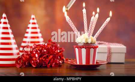 Lighitng Geburtstag Kuchen mit Kerzen und Geschenke gegen eine rustikale Holz Hintergrund. Stockfoto