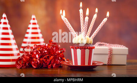 Geburtstag Kuchen mit Kerzen und Geschenke gegen eine rustikale Holz Hintergrund. Stockfoto