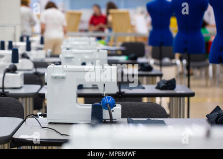 Nterior von garment Factory Shop. Schließt Atelier mit mehreren Nähmaschinen. Anpassung der Industrie. Stockfoto