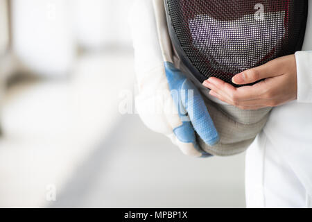 Nahaufnahme eines Fechter in Weiß fechten Anzug und Hand ihre Maske. Stockfoto