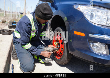 Ein Servicetechniker oder Person ein Reserve Reifen oder Reifen mit einem Schlagschrauber. Stockfoto