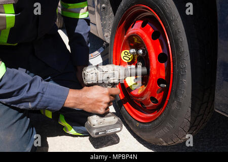 Ein Servicetechniker oder Person ein Reserve Reifen oder Reifen mit einem Schlagschrauber. Stockfoto
