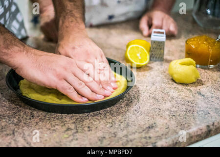 Händen Teig für Dessert in der Backform anordnen Pan vor der Verbreitung des Staus. Stockfoto