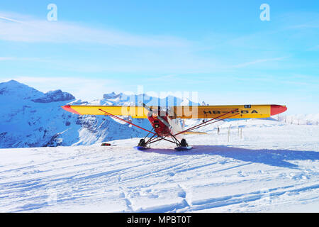 Maennlichen, Schweiz - 31.12.2013: Gelb Flugzeug am Berg Alpen Gipfel in Maennlichen im Winter Schweiz Stockfoto