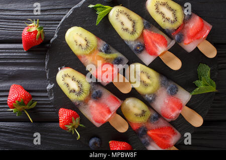 Hausgemachte Obst Eis aus frischen Erdbeeren, Kiwi und Blaubeeren mit Minze closeup auf einen Tisch. Horizontal oben Ansicht von oben Stockfoto