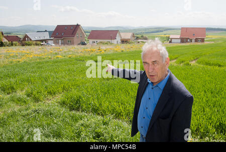 03. Mai 2018, Deutschland, Ottenstein: Bürgermeister Manfred Weiner Punkte an Bauland, die kostenlos ist und bereits entwickelte Land, das verschenkt wurde, am Ortsrand. Menschen, die in Ottenstein im Landkreis Holzminden zu errichten wollen, haben noch nichts für das Grundstück zu zahlen. Seit 2015 hat die Gemeinschaft verspricht Land kostenlos an junge Familien. Dabei wird die 950 - Bürger - Dorf Pläne zur Bekämpfung der sinkenden Zahl der Einwohner. Foto: Julian Stratenschulte/dpa Stockfoto